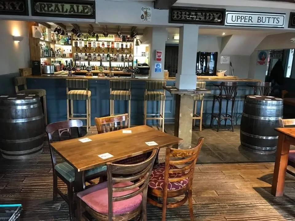 The bar at the Golden Lion, Bedhampton, with blue painted counter, bar stools and cask barrel tables